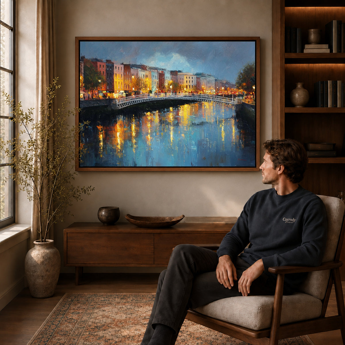 city bridge reflections canvas art in a walnut frame above a console beside a seated man.