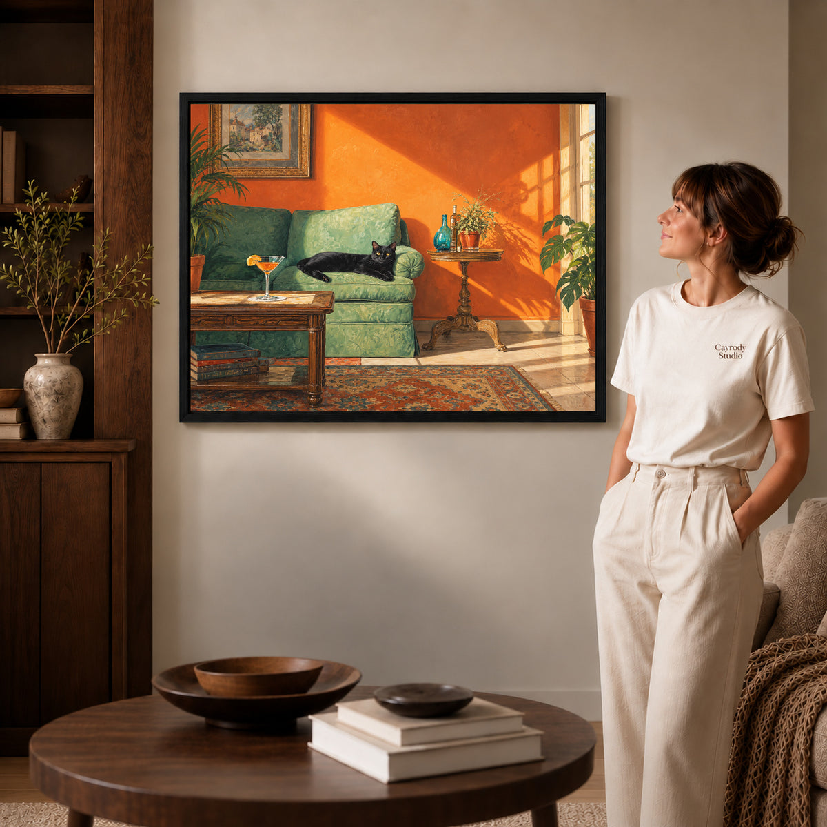 sunlit cat lounge canvas art in a black frame beside a woman and round wooden table.