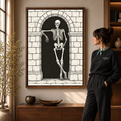 leaning skeleton guest canvas art in a walnut frame beside a standing woman and wooden console.