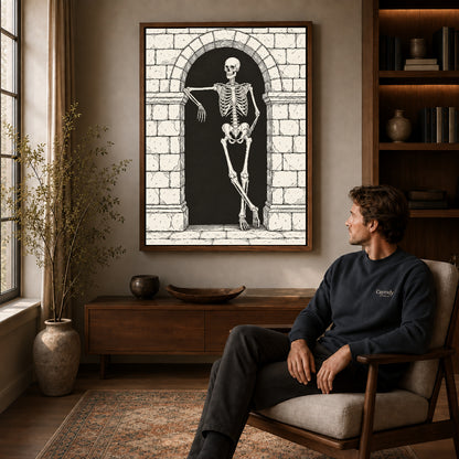 leaning skeleton guest canvas art in a walnut frame above a console beside a seated man.