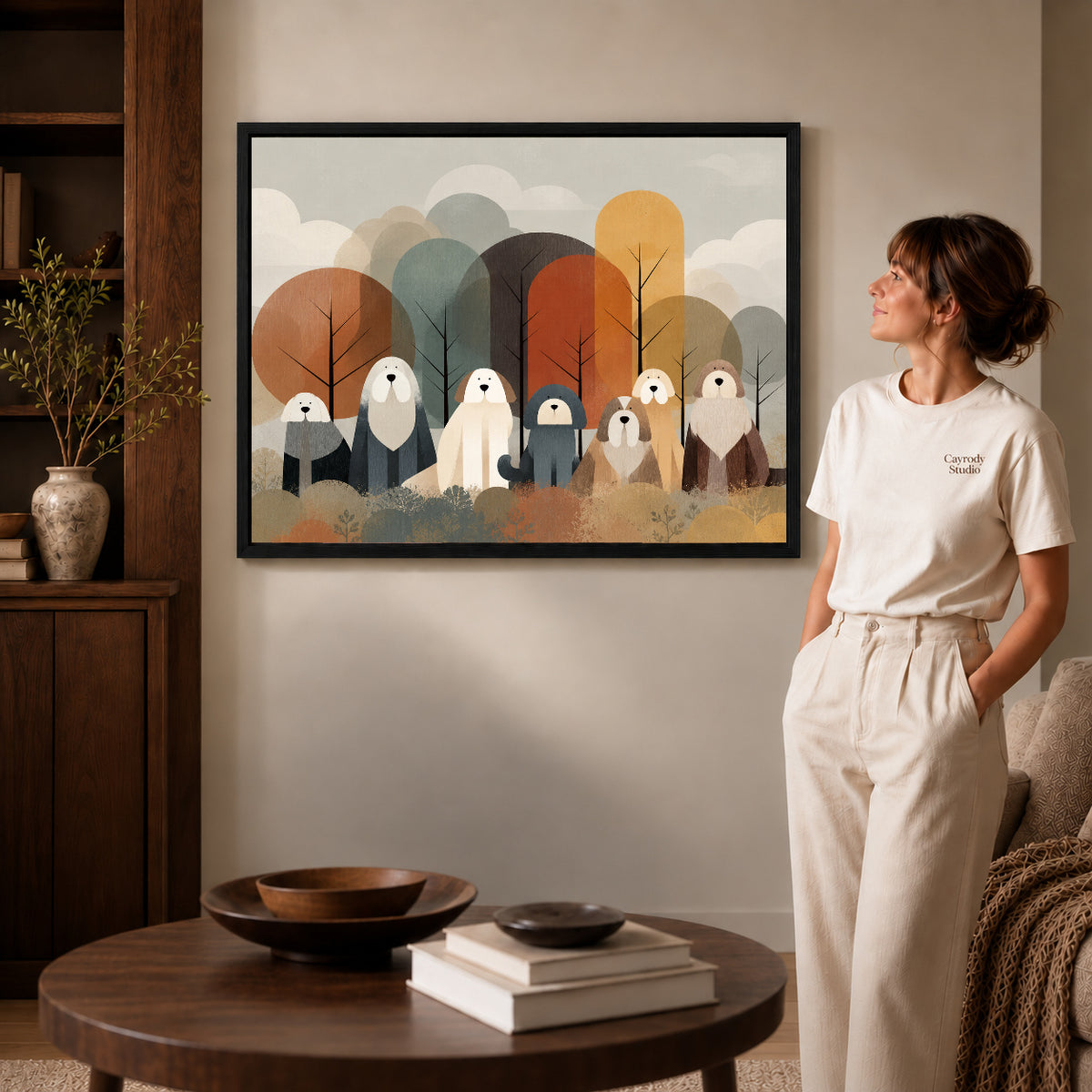 shaggy woodland companions canvas art in a black frame beside a woman and round wooden table.