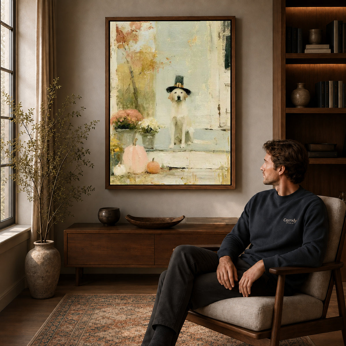 pilgrim porch dog canvas art in a walnut frame above a console beside a seated man.