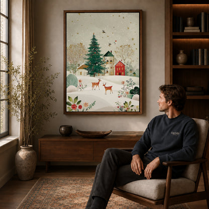 snowy village deer canvas art in a walnut frame above a console beside a seated man.