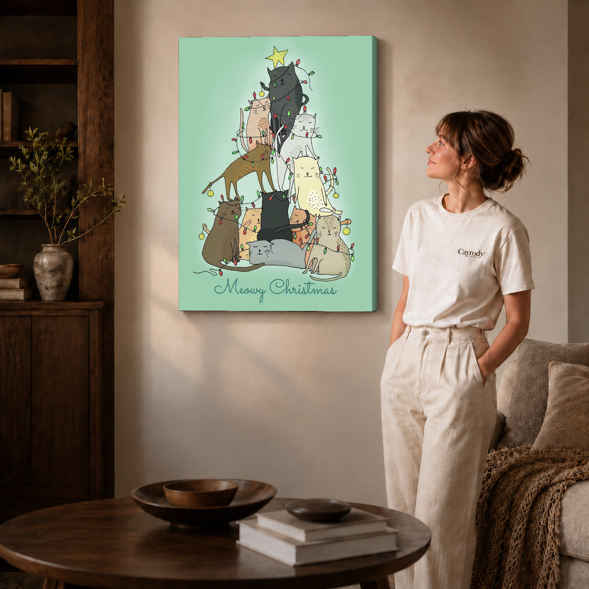 meowy christmas cats canvas art on gallery-wrapped canvas with natural edge shading beside a standing woman.