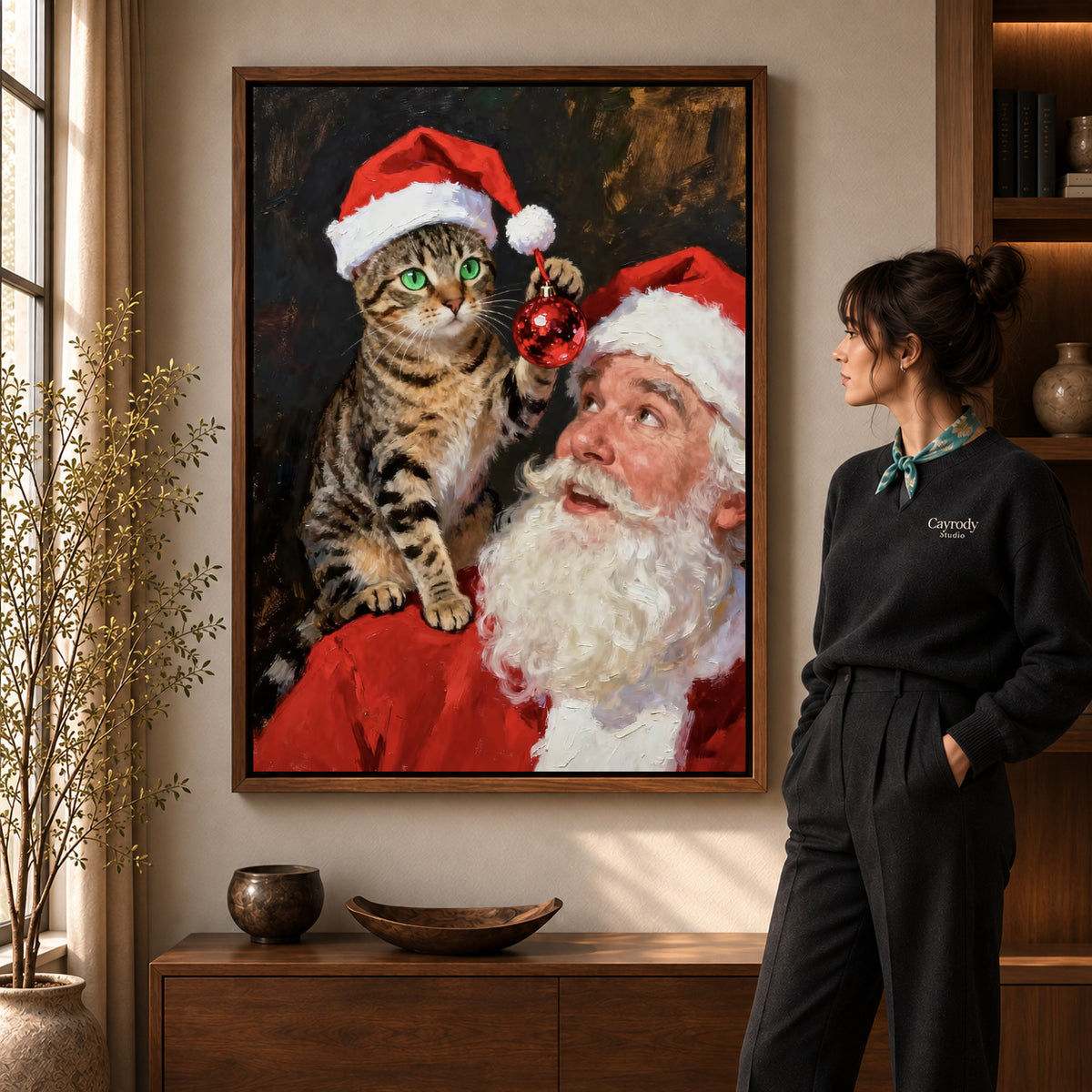 santa cat surprise canvas art in a walnut frame beside a standing woman and wooden console.