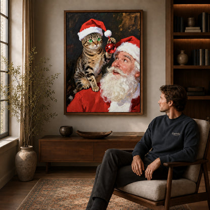 santa cat surprise canvas art in a walnut frame above a console beside a seated man.