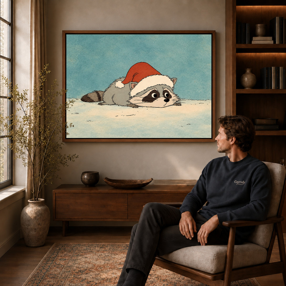 sleepy holiday raccoon canvas art in a walnut frame above a console beside a seated man.