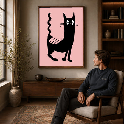 wavy tail cat canvas art in a walnut frame above a console beside a seated man.