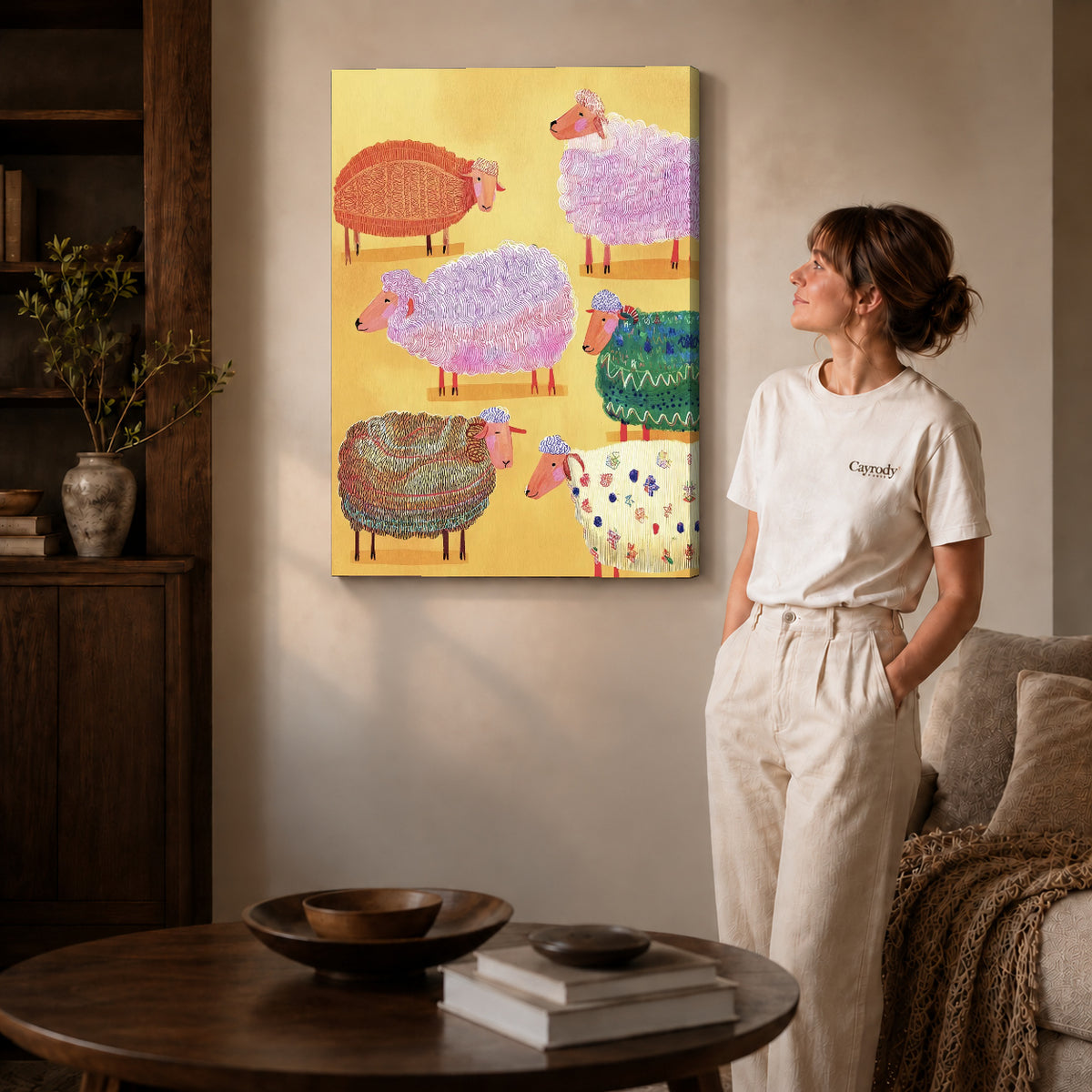 colorful knitted sheep canvas art on gallery-wrapped canvas with natural edge shading beside a standing woman.