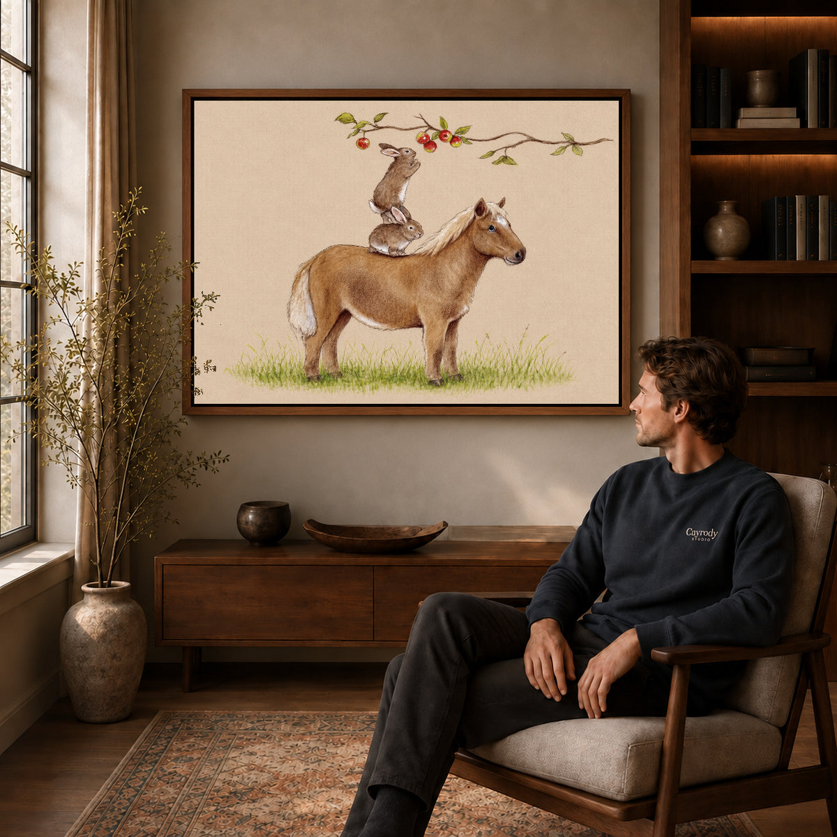 orchard animal team canvas art in a walnut frame above a console beside a seated man.