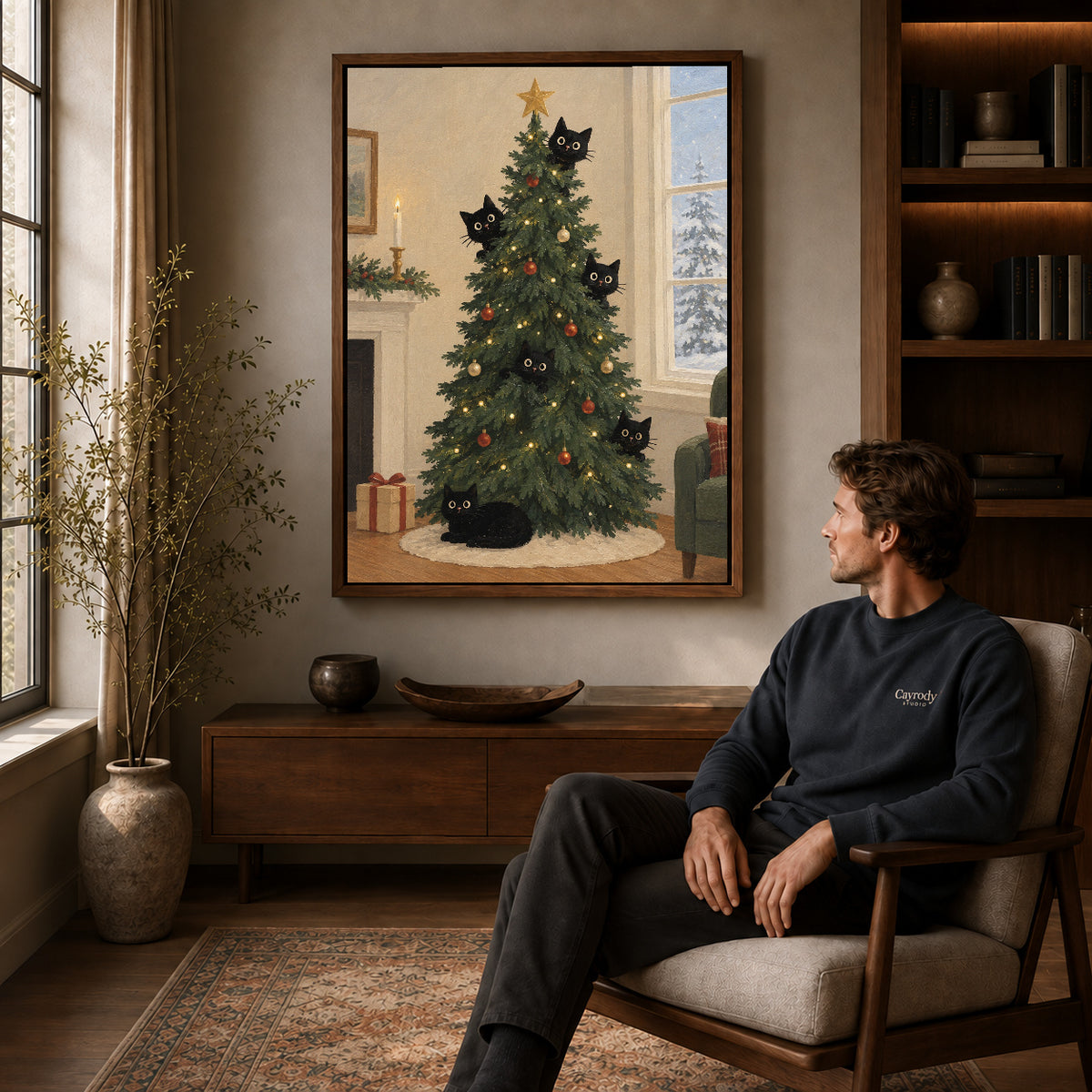 christmas tree cats canvas art in a walnut frame above a console beside a seated man.
