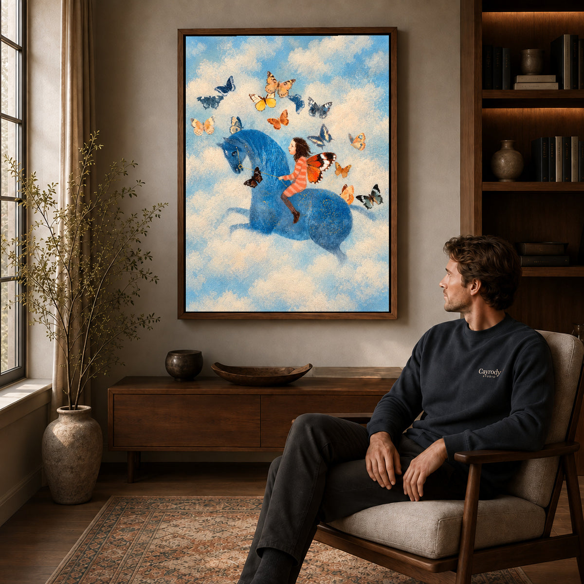 butterfly horse dream canvas art in a walnut frame above a console beside a seated man.