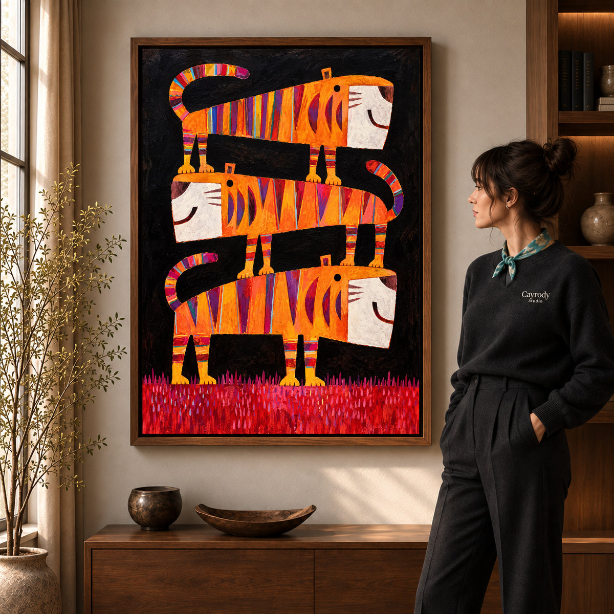 striped tiger trio canvas art in a walnut frame beside a standing woman and wooden console.
