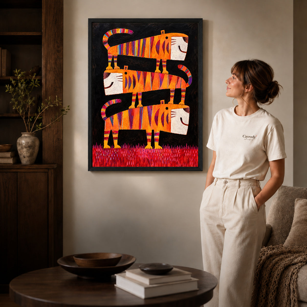 striped tiger trio canvas art in a black frame beside a woman and round wooden table.