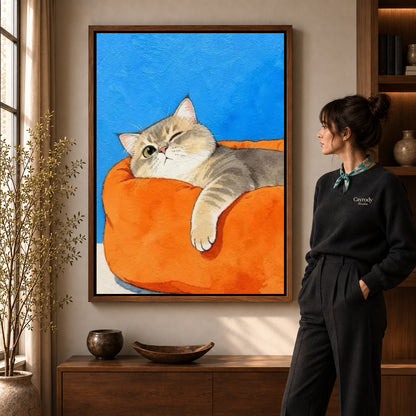 winking armchair cat canvas art in a walnut frame beside a standing woman and wooden console.