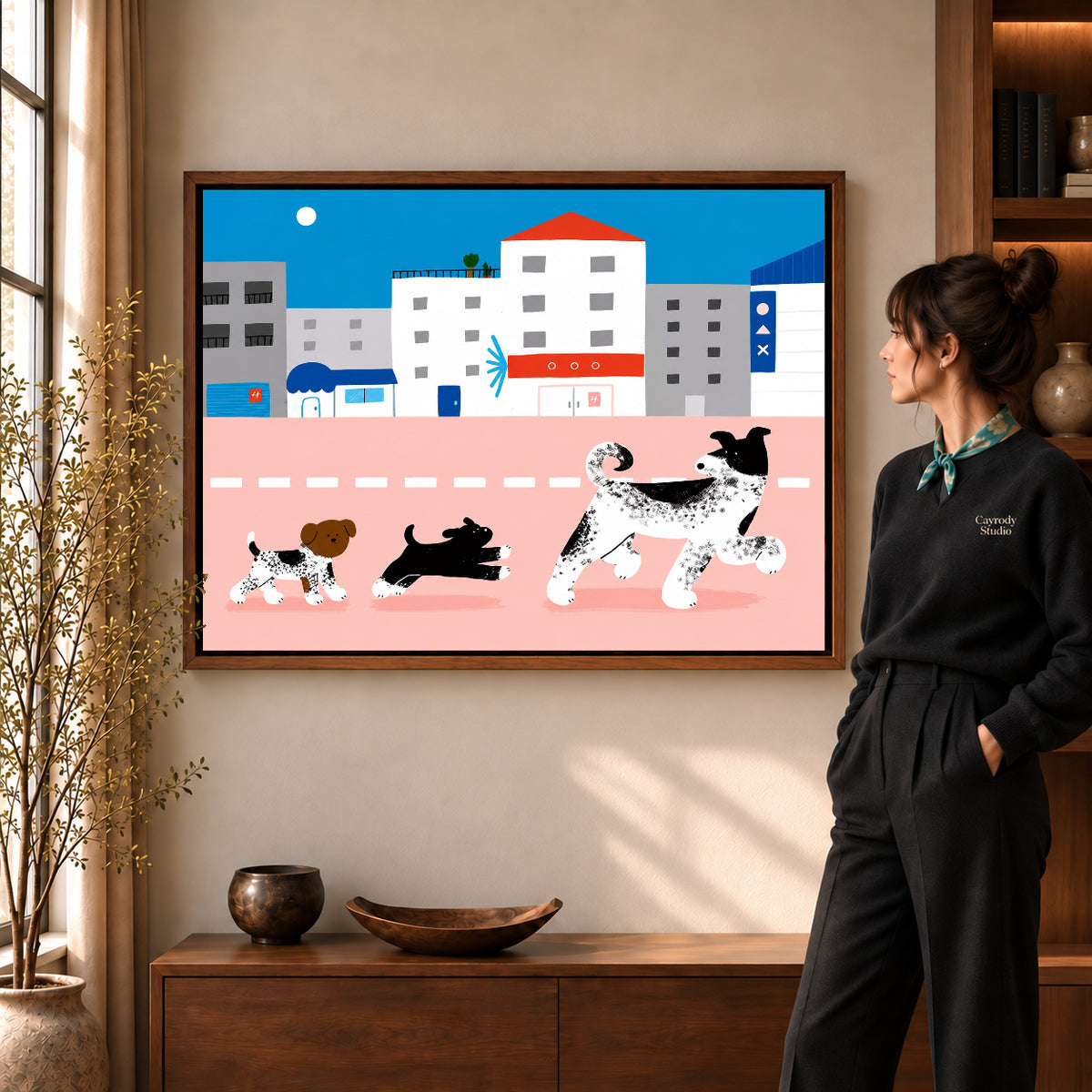 city dog parade canvas art in a walnut frame beside a standing woman and wooden console.