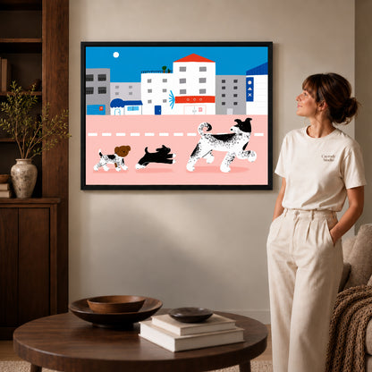 city dog parade canvas art in a black frame beside a woman and round wooden table.