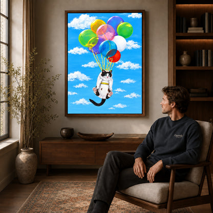 balloon cat adventure canvas art in a walnut frame above a console beside a seated man.