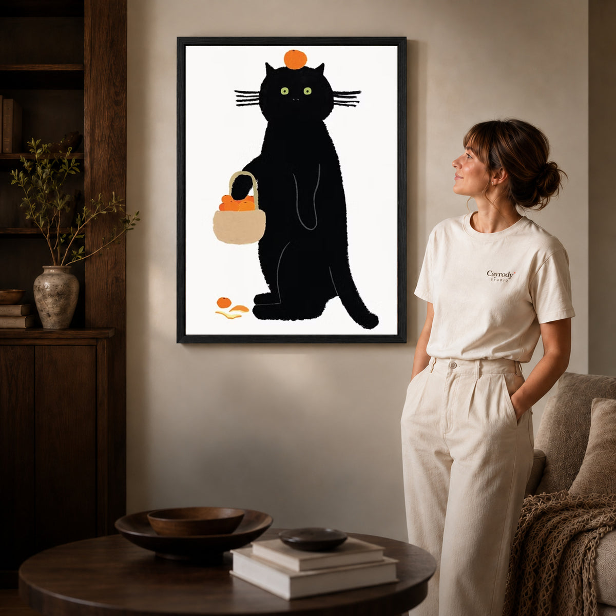 orange basket cat canvas art shown in the black frame option against a softly lit wall.
