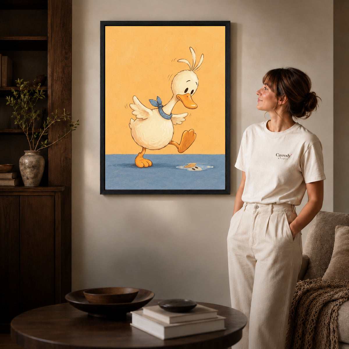 puddle step duck canvas art in a black frame beside a woman and round wooden table.