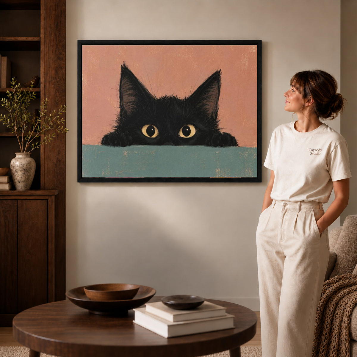 curious peeking kitten canvas art shown in the black frame option against a softly lit wall.