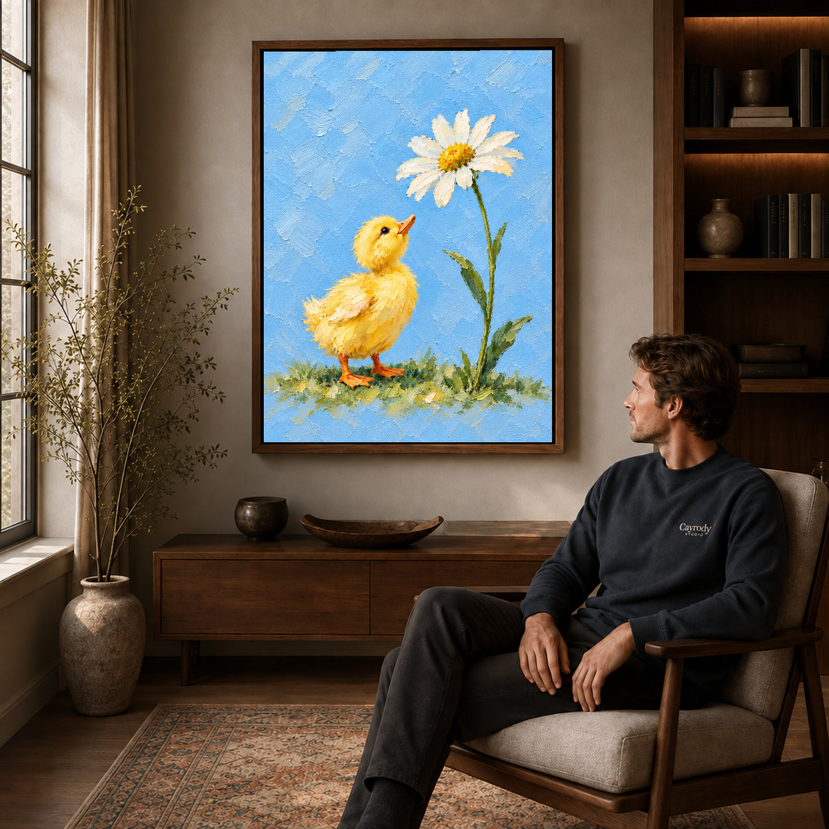 duckling daisy wonder canvas art in a walnut frame above a console beside a seated man.