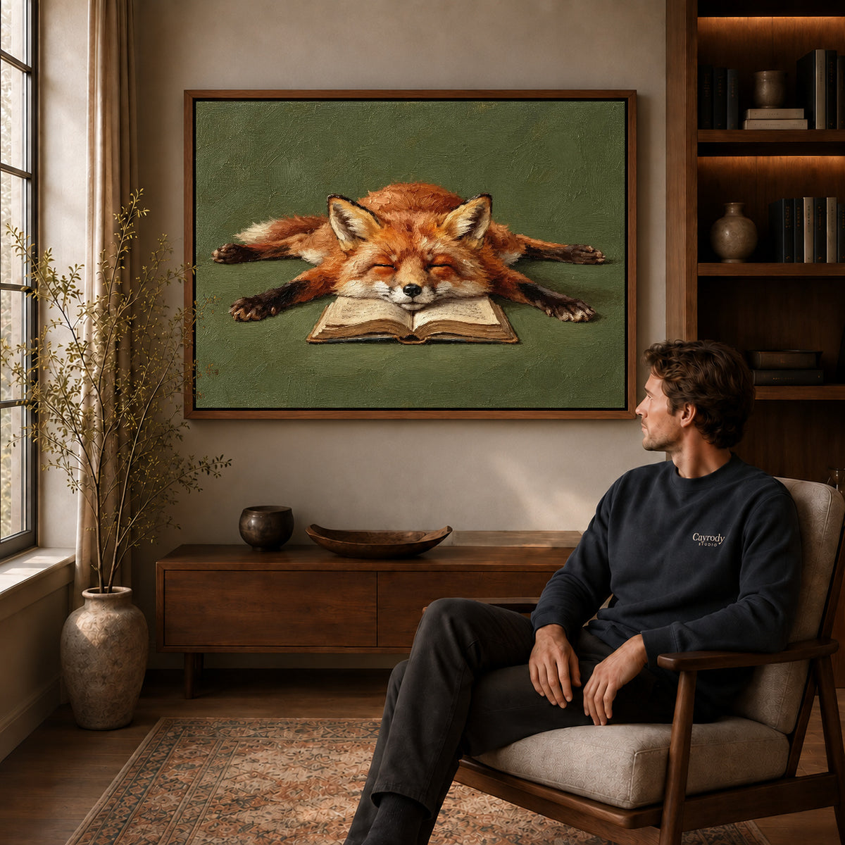 sleepy book fox canvas art in a walnut frame above a console beside a seated man.