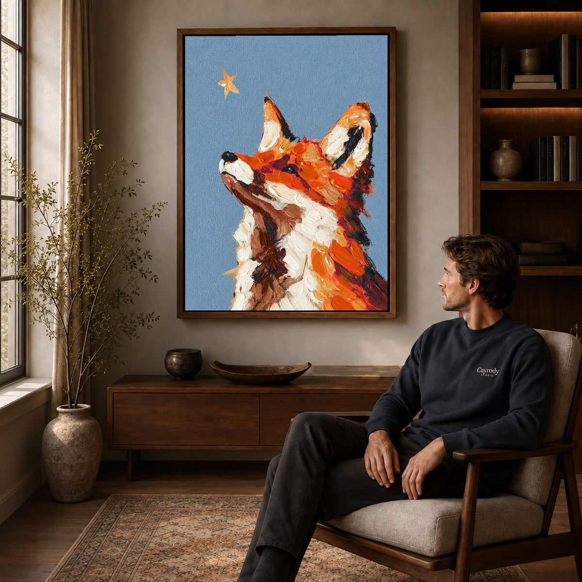 stargazing fox portrait canvas art in a walnut frame above a console beside a seated man.