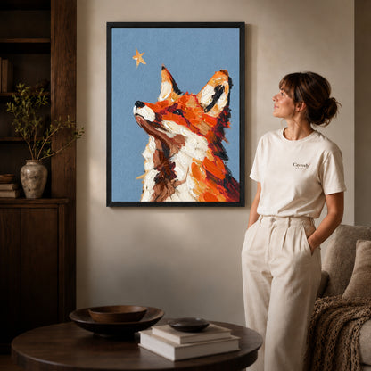 stargazing fox portrait canvas art in a black frame beside a woman and round wooden table.
