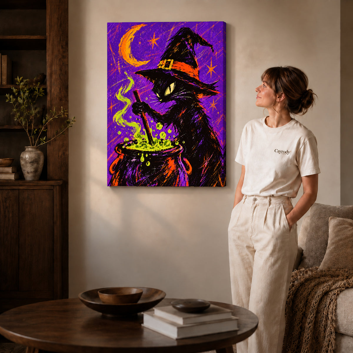witch cat cauldron canvas art on gallery-wrapped canvas with natural edge shading beside a standing woman.
