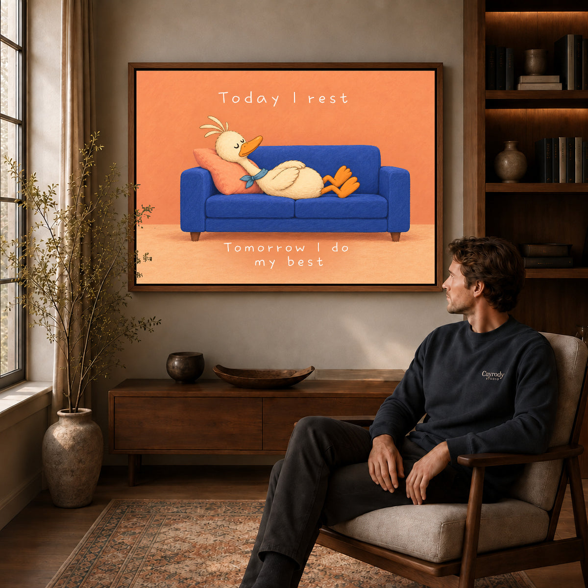 rest day duck canvas art in a walnut frame above a console beside a seated man.