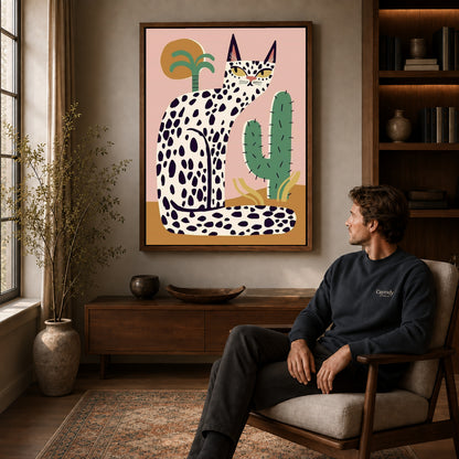 spotted desert cat canvas art in a walnut frame above a console beside a seated man.