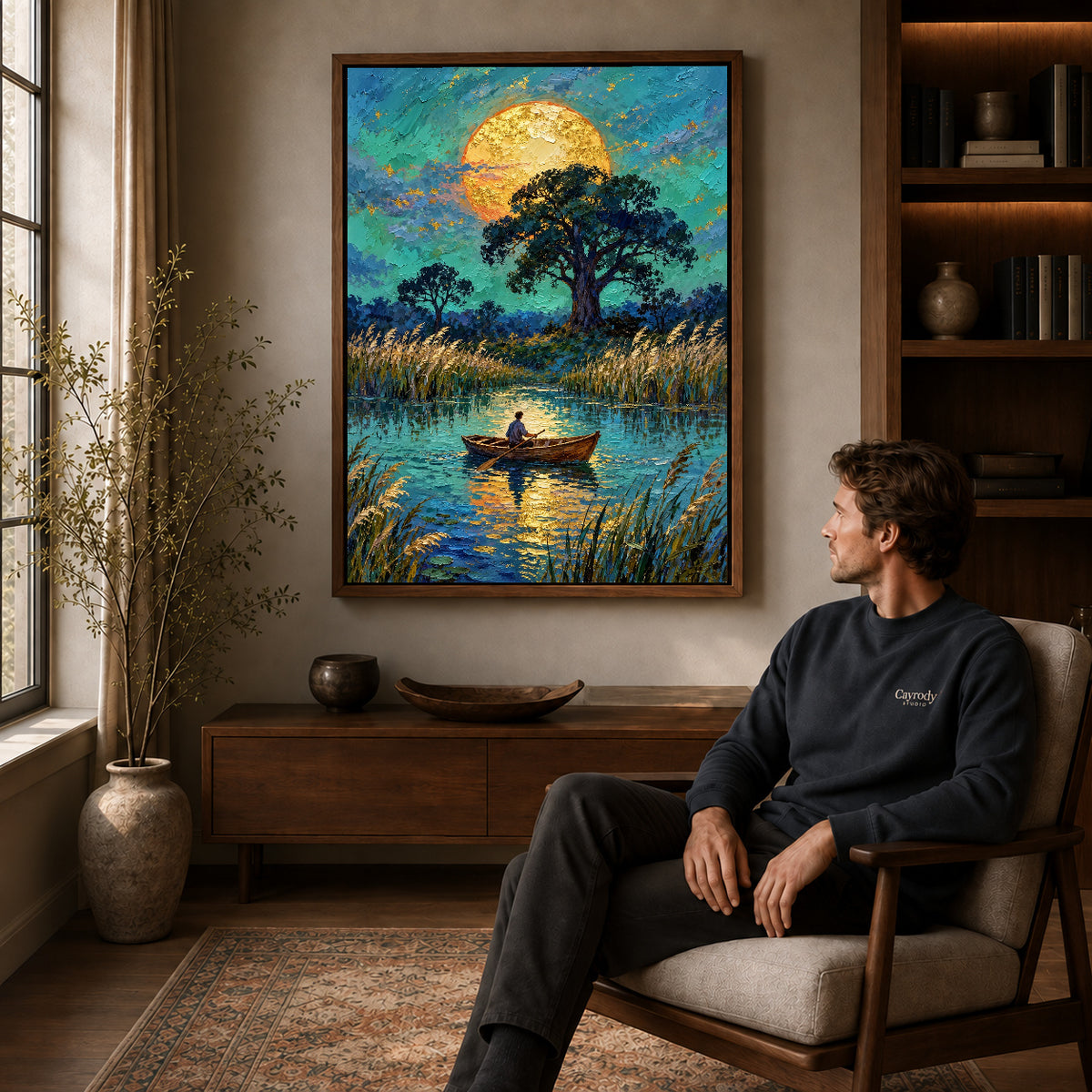 moonlit pond journey canvas art in a walnut frame above a console beside a seated man.