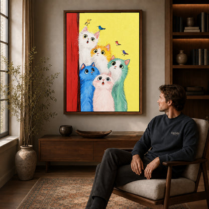 colorful cat chorus canvas art in a walnut frame above a console beside a seated man.