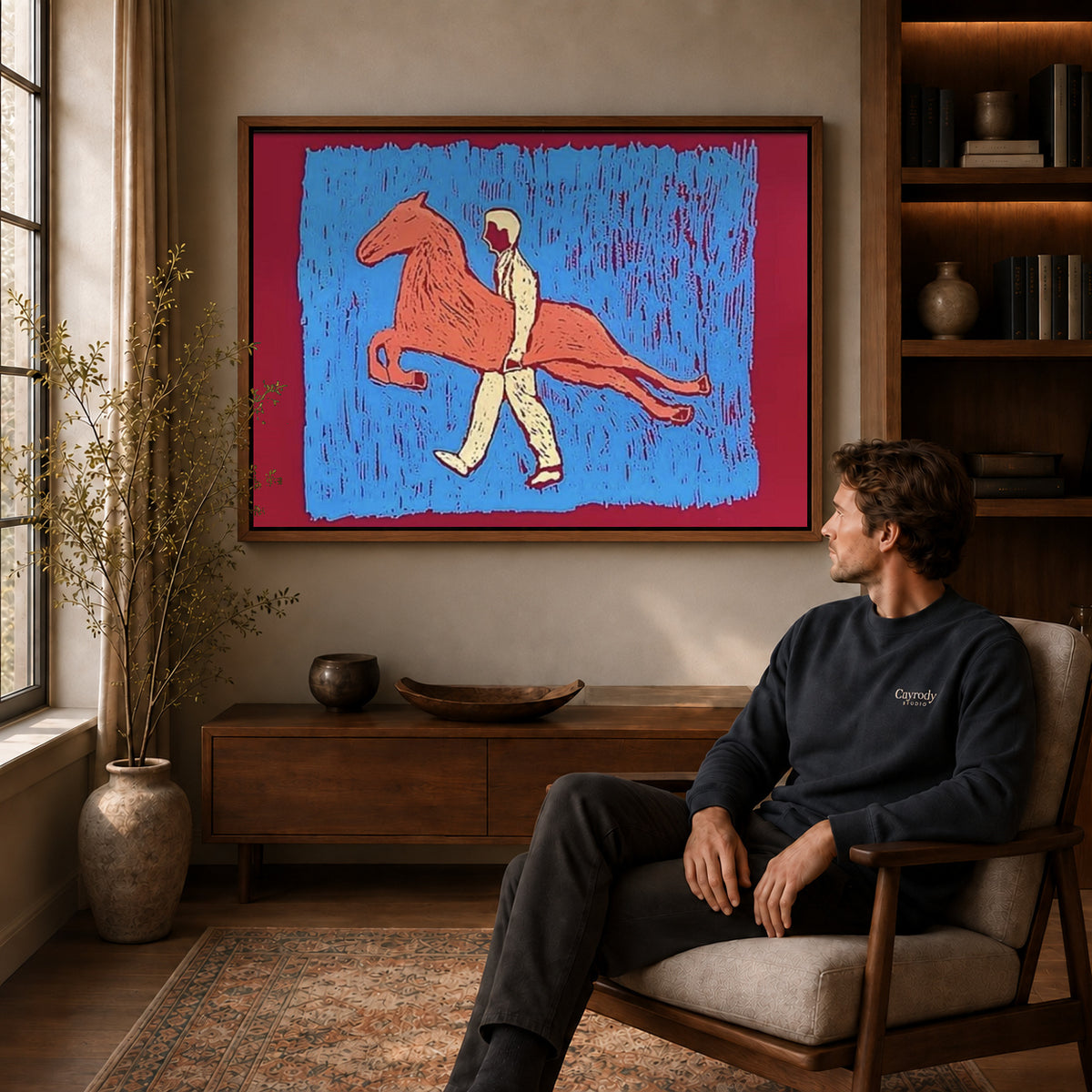 carrying my horse canvas art in a walnut frame above a console beside a seated man.