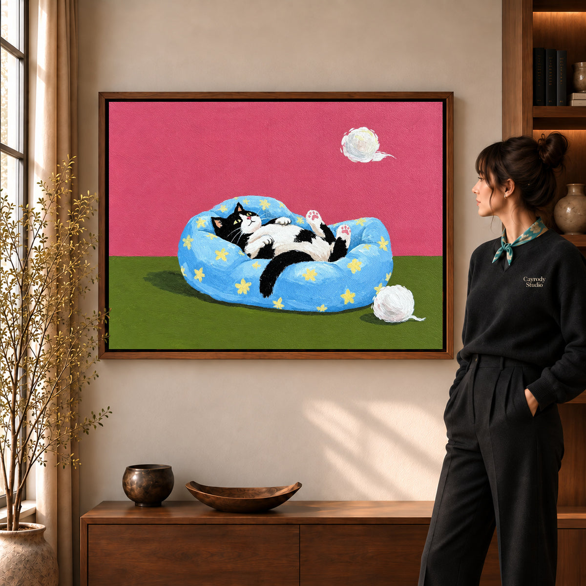 star bed cat canvas art shown in the walnut frame option within a warm living room.