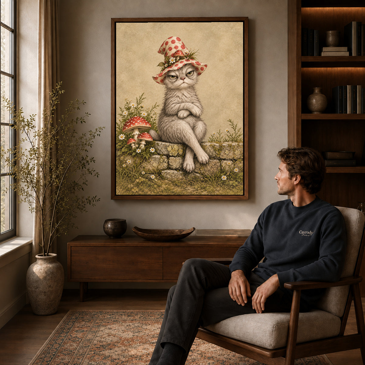 grumpy garden witch canvas art in a walnut frame above a console beside a seated man.