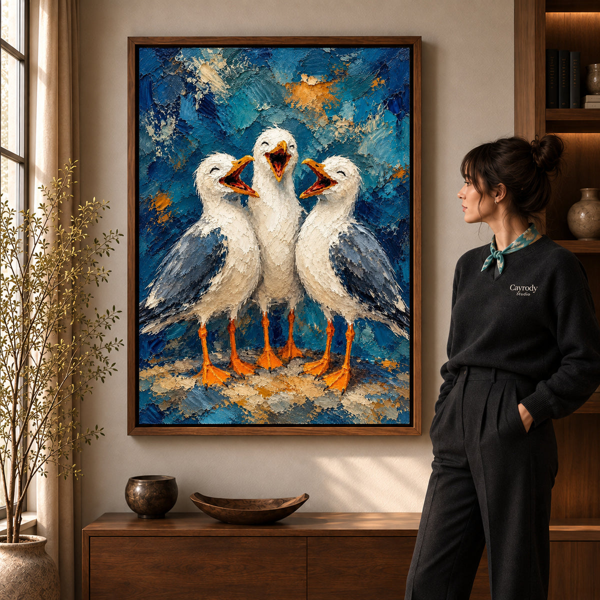 laughing seagull trio canvas art in a walnut frame beside a standing woman and wooden console.