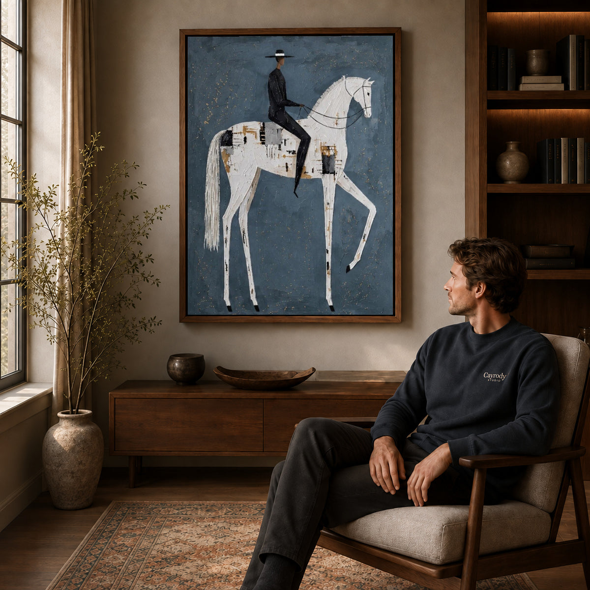 quiet equestrian poise canvas art in a walnut frame above a console beside a seated man.