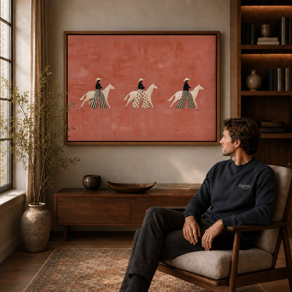 patterned rider parade canvas art in a walnut frame above a console beside a seated man.