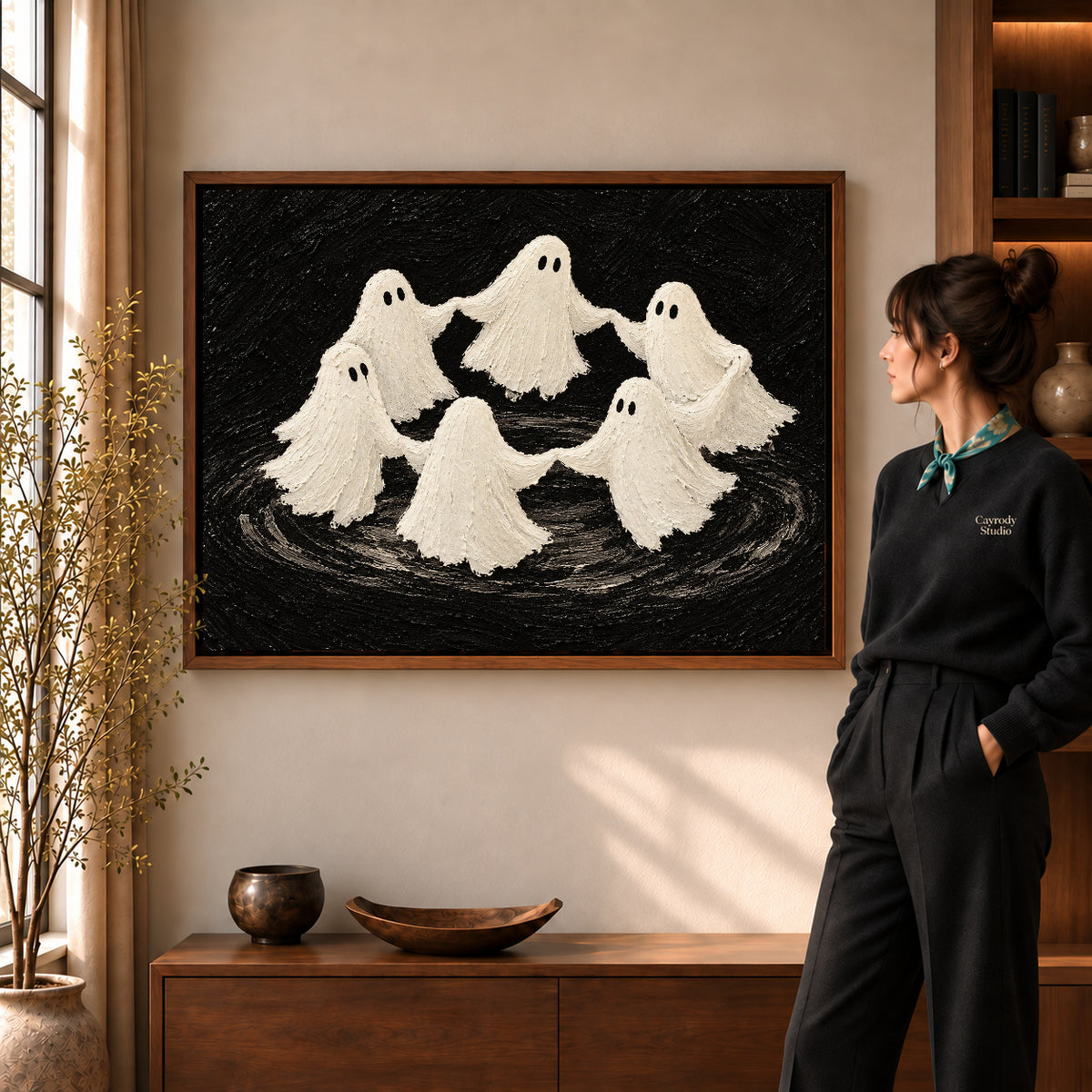 dancing ghost circle canvas art in a walnut frame beside a standing woman and wooden console.