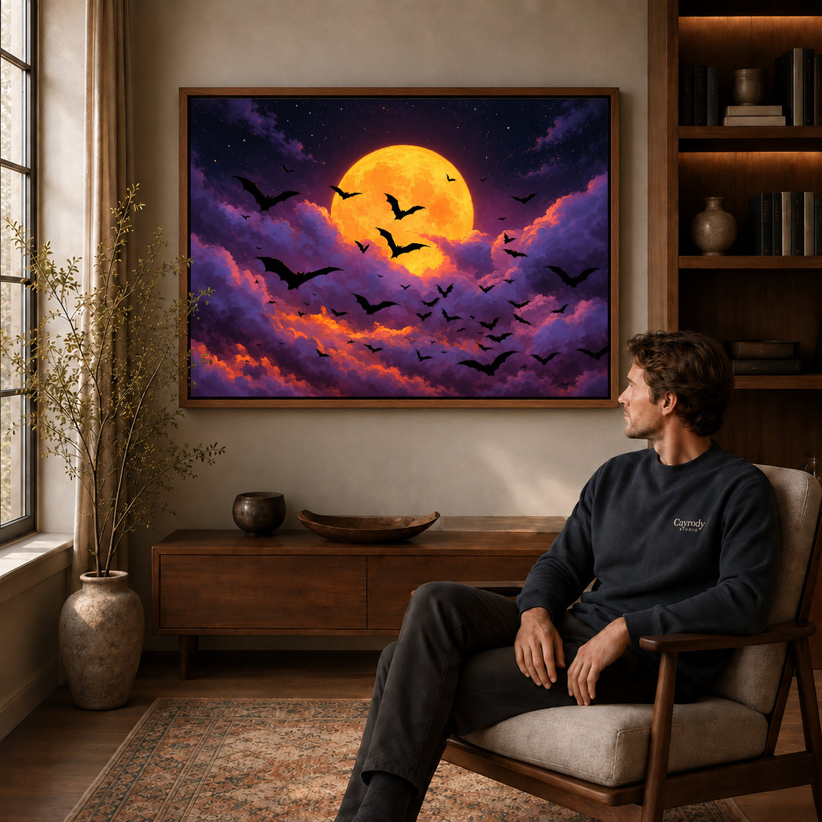 golden moon bats canvas art in a walnut frame above a console beside a seated man.
