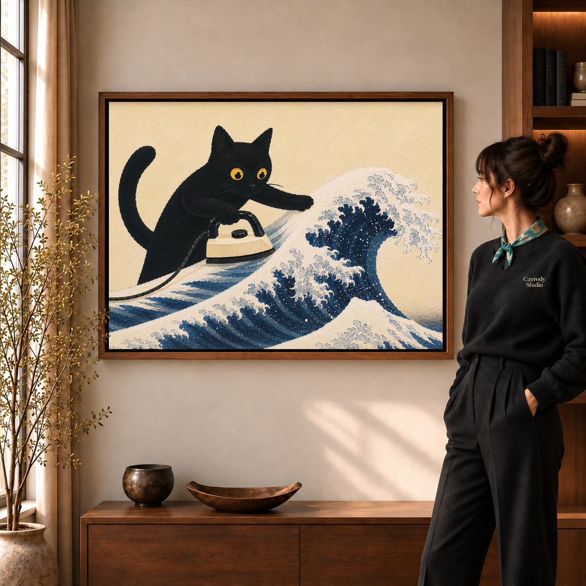 cat wave ironing canvas art in a walnut frame beside a standing woman and wooden console.