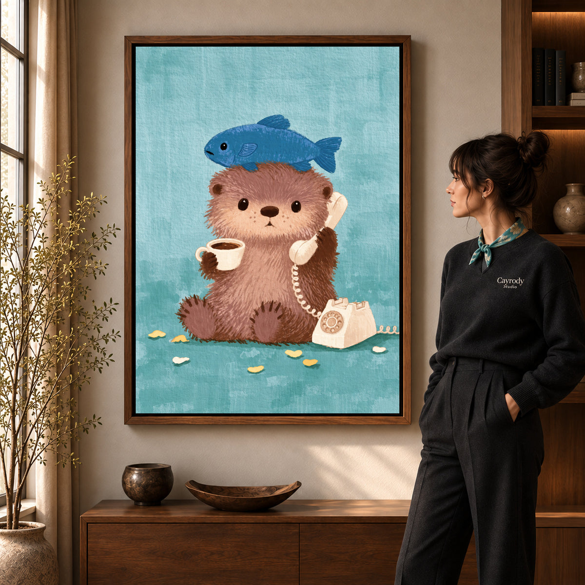 otter coffee call canvas art in a walnut frame beside a standing woman and wooden console.