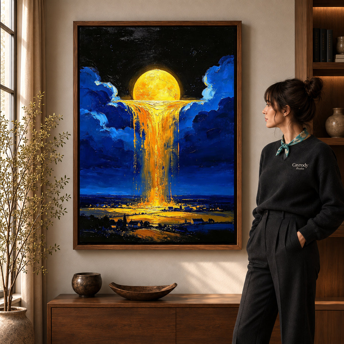 golden sky cascade canvas art in a walnut frame beside a standing woman and wooden console.