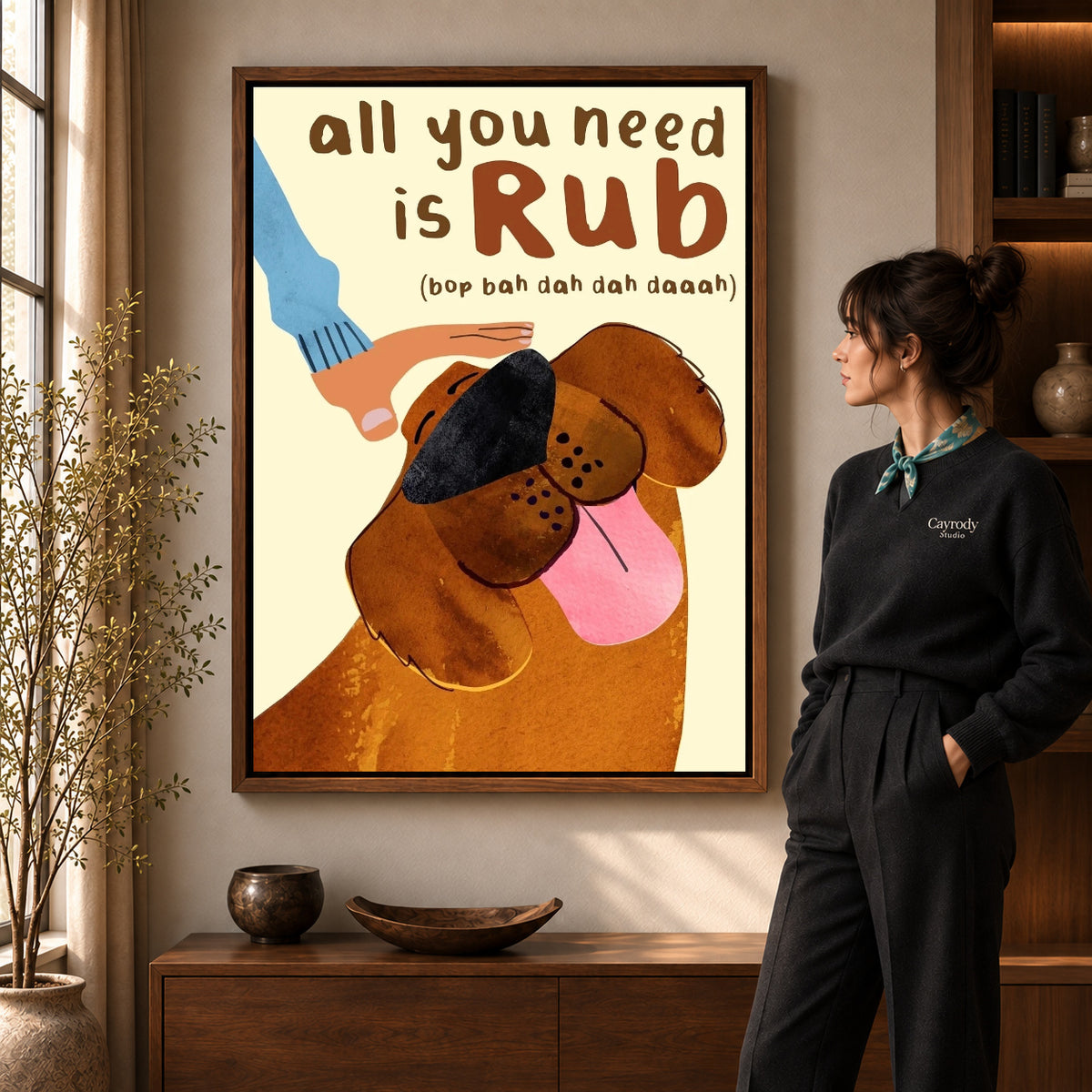 all you need rub canvas art in a walnut frame beside a standing woman and wooden console.