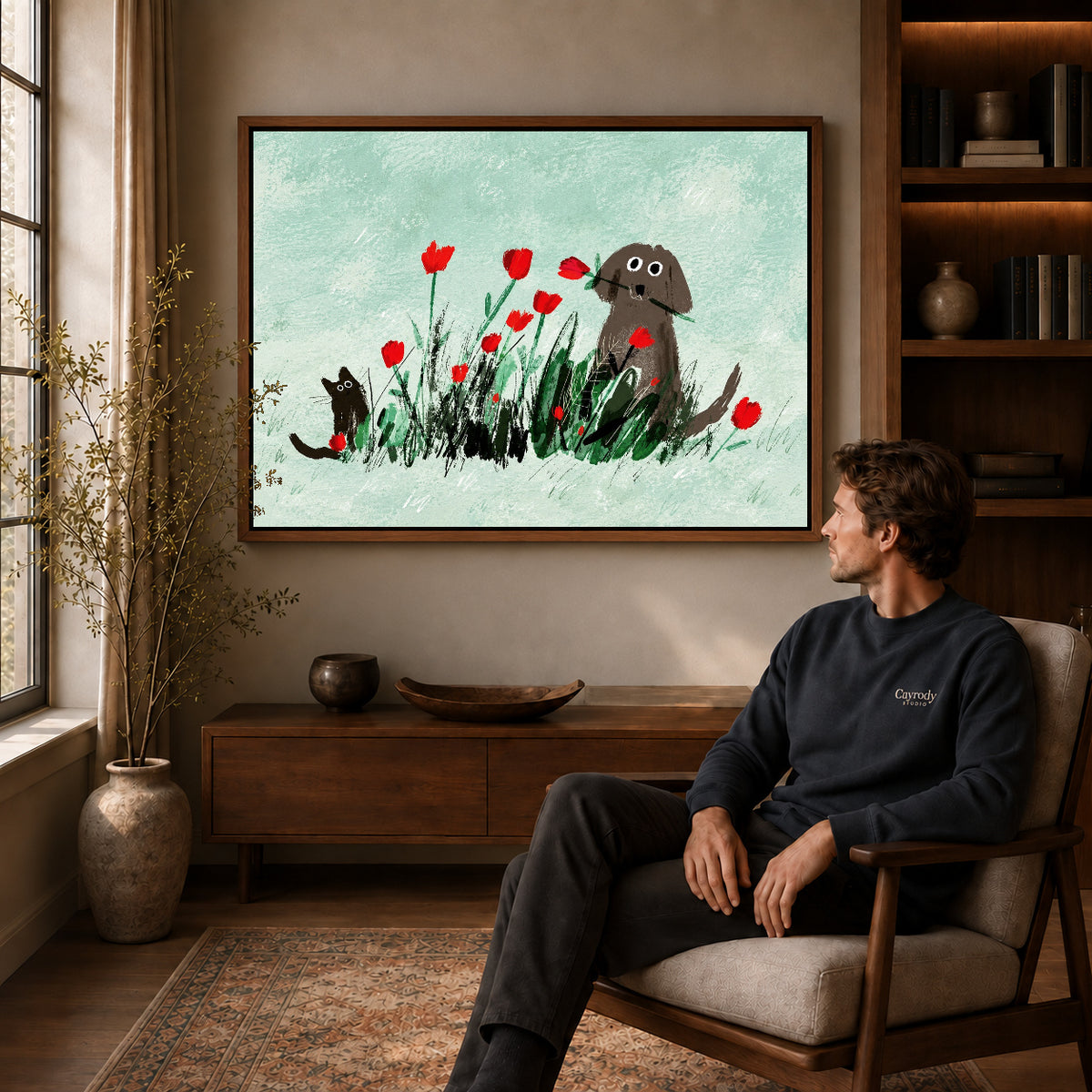 dog cat tulip garden canvas art in a walnut frame above a console beside a seated man.
