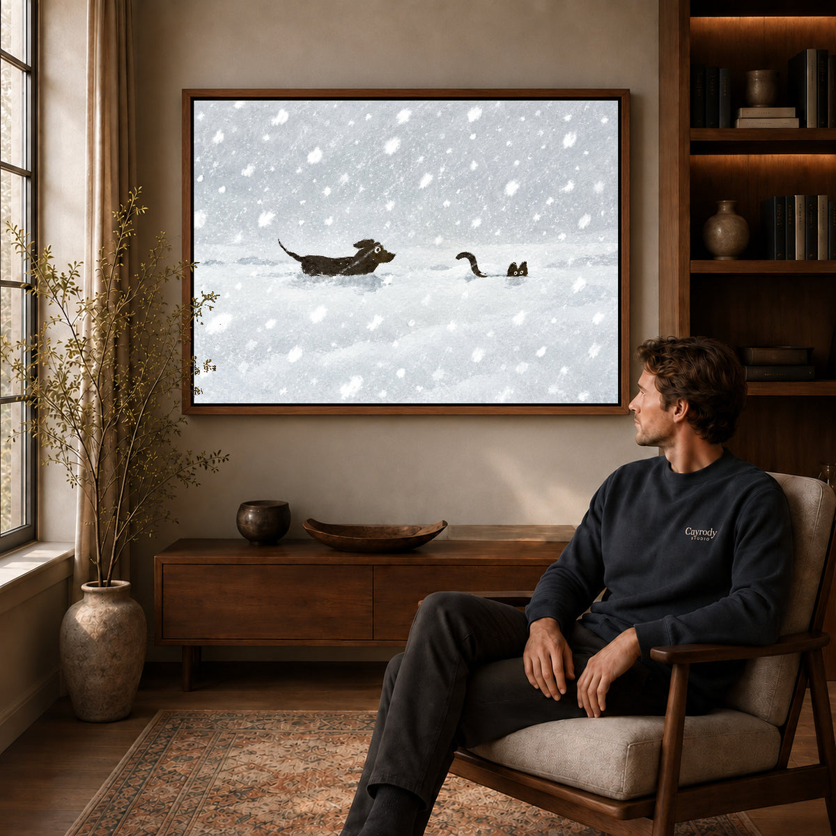 snow chase companions canvas art in a walnut frame above a console beside a seated man.