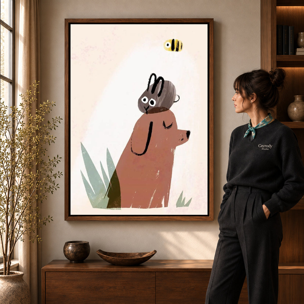 dog rabbit daydream canvas art in a walnut frame beside a standing woman and wooden console.