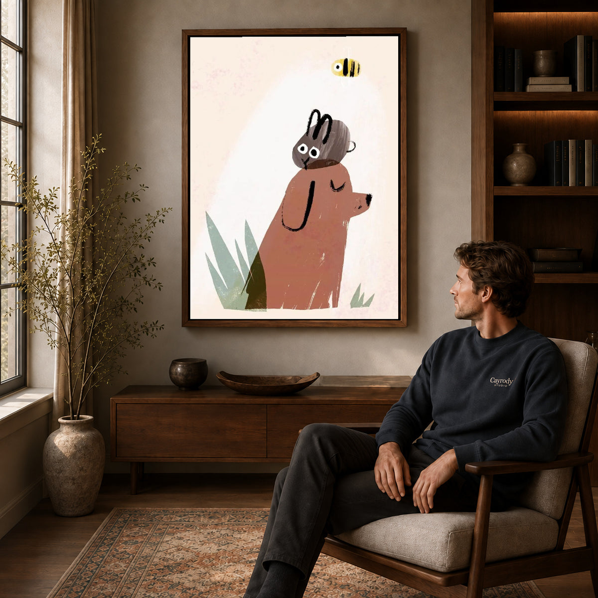 dog rabbit daydream canvas art in a walnut frame above a console beside a seated man.
